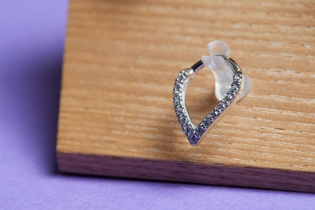 Mooie piercingsieraden op houten display Macro-opname Selectieve aandacht