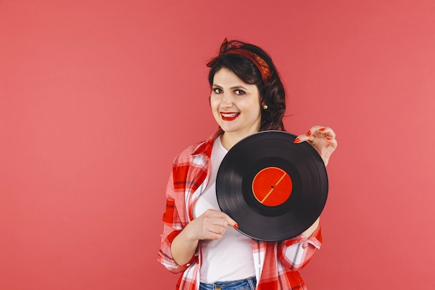 Mooie pin-up vrouw met vinyl geïsoleerd over thered backgruond.