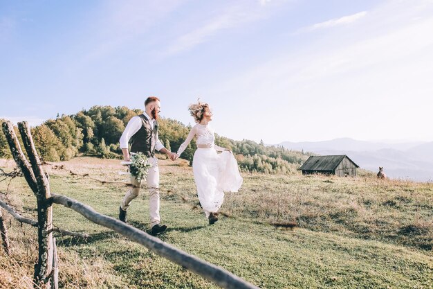 Mooie prachtige bruid poseren voor bruidegom en plezier hebben, luxe ceremonie in de bergen