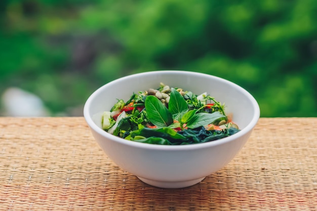 Mooie rauwe veganistische salade van groene bladeren mix groenten in witte plaat Kookrecept Gemengde tomaat wortel bloemkool gesneden peterselie koriander dille groen komkommer basilicum pompoenpitten zeewier