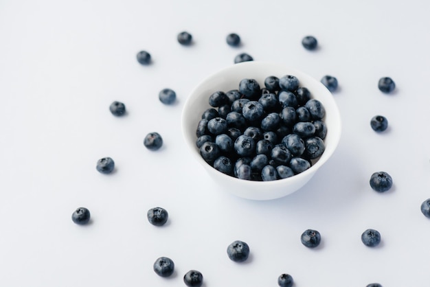 Mooie rijpe bosbessen in een glazen kom op een witte achtergrond. Gezonde voeding en vitamines.