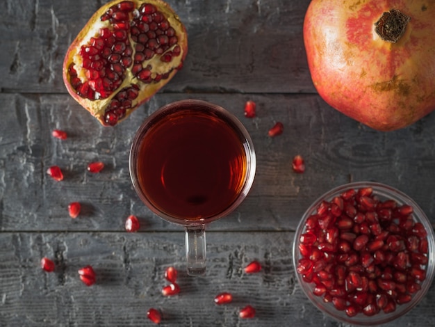 Mooie rijpe granaatappels op een houten tafel met granaatappelsap. Drink nuttig voor de gezondheid. Plat leggen.