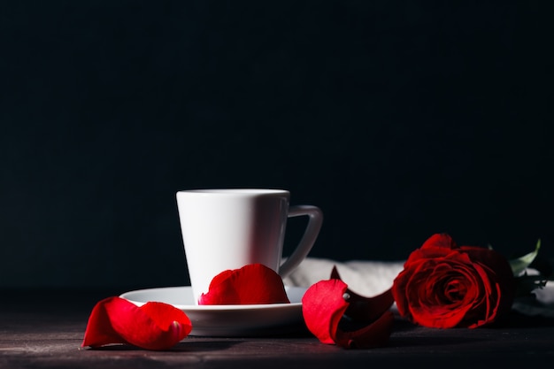 mooie rode roos op zwarte tafel met koffie