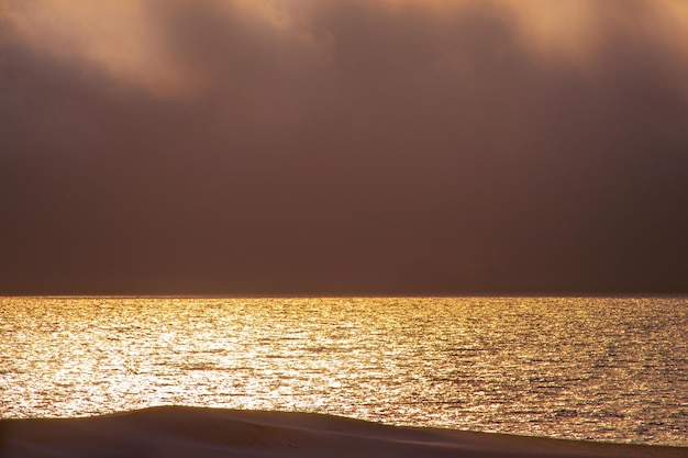 Mooie rode zonsondergang donkere wolken en de atlantische oceaan aan de horizon