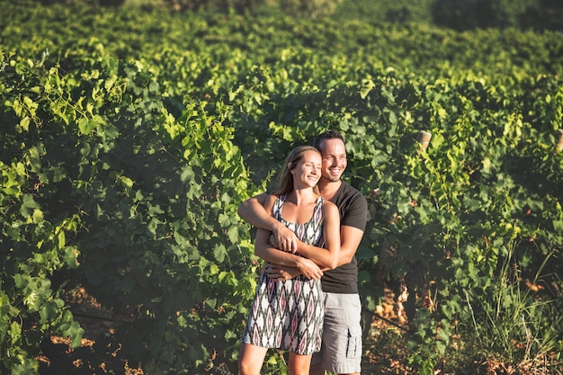 Mooie romantische paar man en vrouw jonge volwassenen die samen in wijngaarden wandelen
