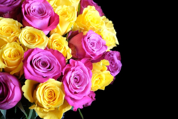 Mooie ronde boeket van roze en gele rozen bloemen aan de linkerkant van de foto geïsoleerd op zwarte achtergrond close-up