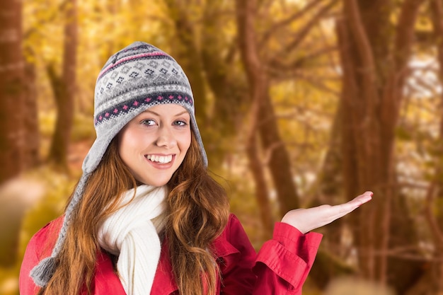 Mooie roodharige in warme kleding tegen een rustige herfstscène in het bos