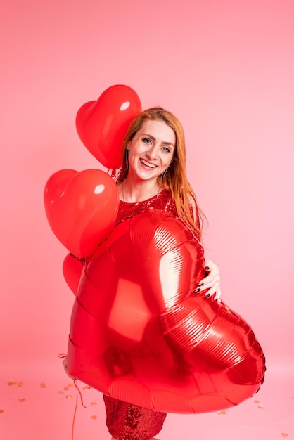 Mooie roodharige meisje met rood hart ballon poseren Happy Valentines Day concept