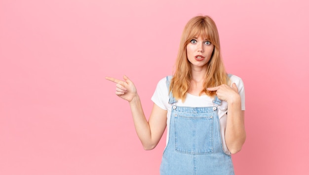 Mooie roodharige vrouw die zich gelukkig voelt en opgewonden naar zichzelf wijst