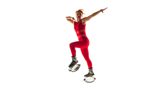 Mooie roodharige vrouw in een rode sportkleding springen in een kangoo