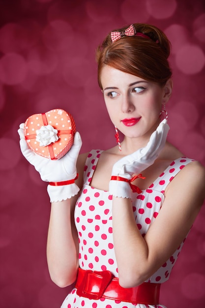 Mooie roodharige vrouwen met cadeau. foto in retro stijl met bokeh op de achtergrond.