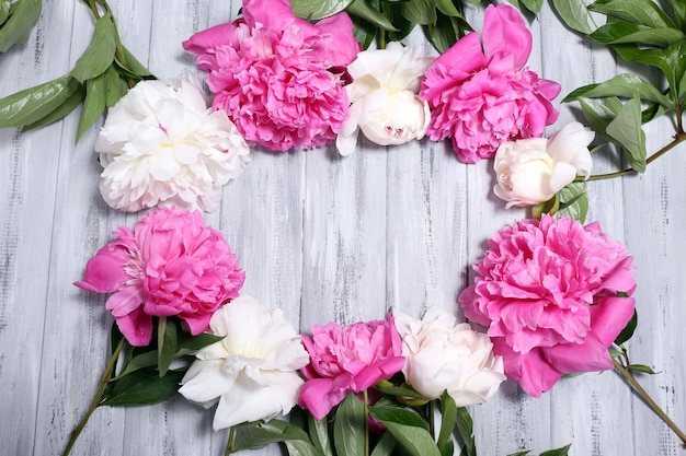 Mooie roze en witte pioenrozen op een houten achtergrond kleur