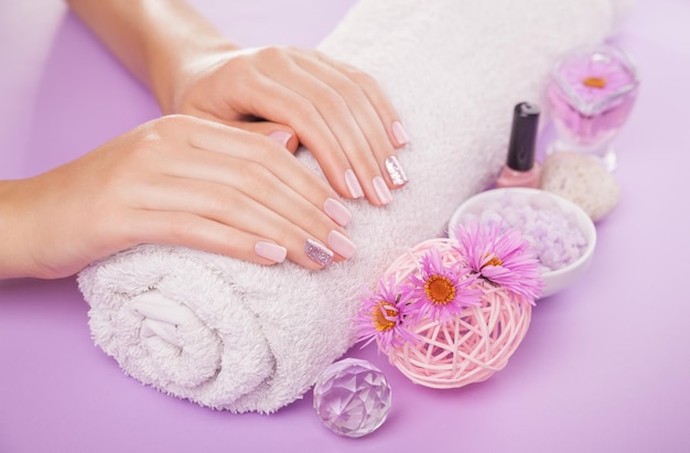 Mooie roze en zilveren manicure met bloemen en spa-benodigdheden