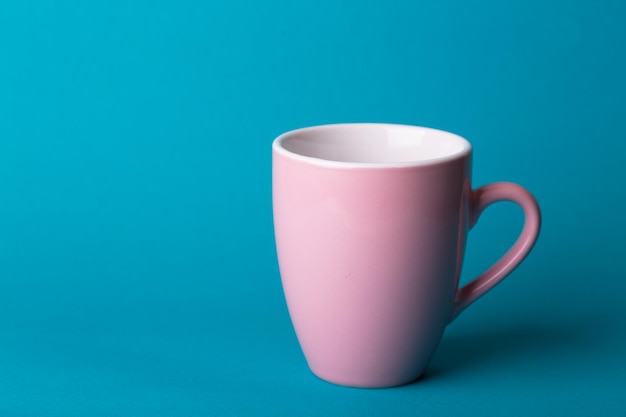 Mooie roze koffiekop op blauwe achtergrond