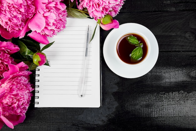 Mooie roze pioen bloemen met laptop en pen