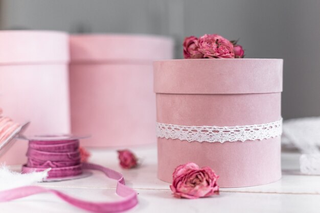 Mooie roze ronde cadeauverpakking is versierd met versmalde rozen