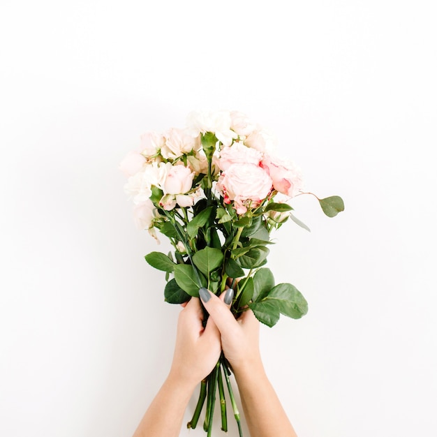 Mooie roze roos bloemboeket in meisjes hand geïsoleerd op wit