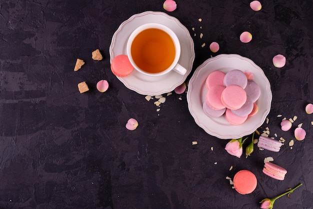 Mooie roze smakelijke bitterkoekjes op een concrete achtergrond