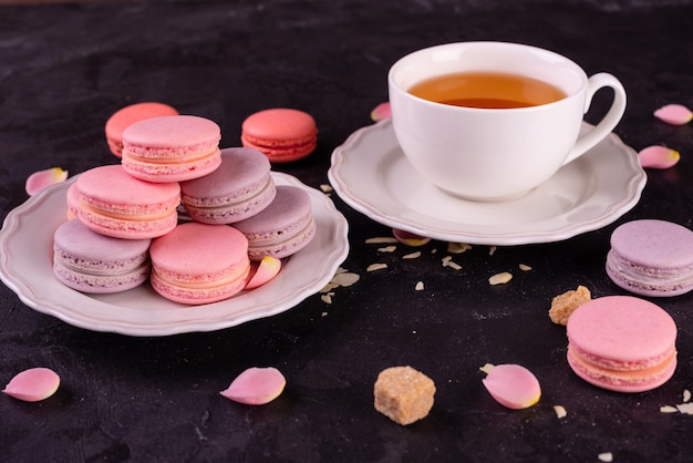 Mooie roze smakelijke bitterkoekjes op een concrete achtergrond