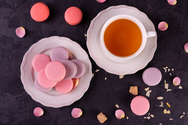 Mooie roze smakelijke bitterkoekjes op een concrete achtergrond