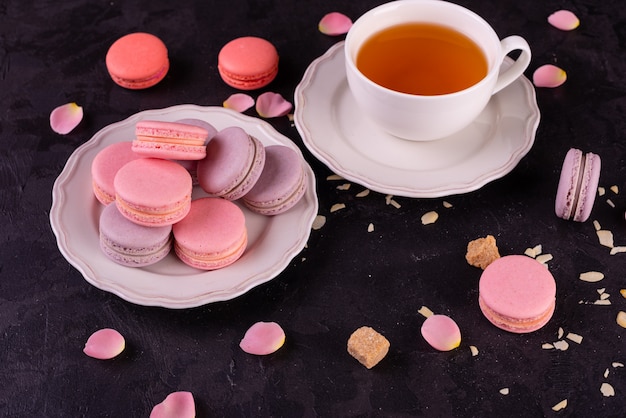 Mooie roze smakelijke bitterkoekjes op een concrete achtergrond