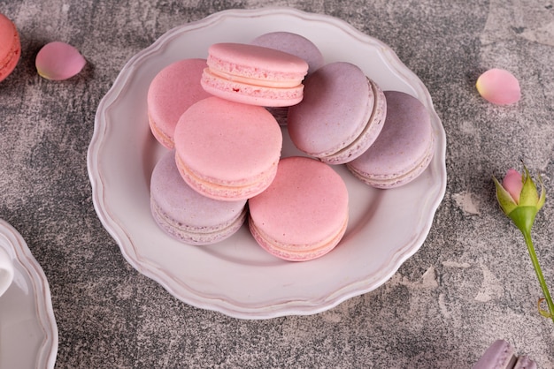 Mooie roze smakelijke bitterkoekjes op een concrete achtergrond