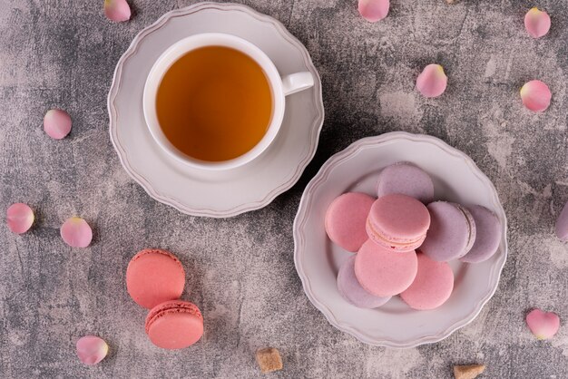 Mooie roze smakelijke bitterkoekjes op een concrete achtergrond