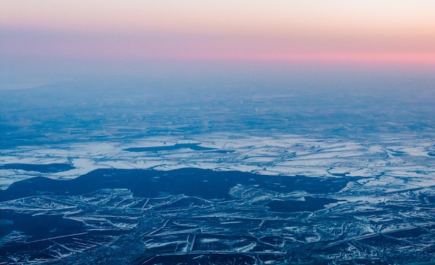 Mooie roze zonsondergang van bovenaf over winterterrein