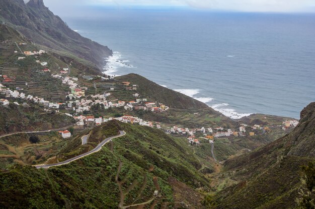 Mooie rustige uitzicht op groene, met gras begroeide steile helling. Tenerife. mooi dorp op de hellingen van de berg.