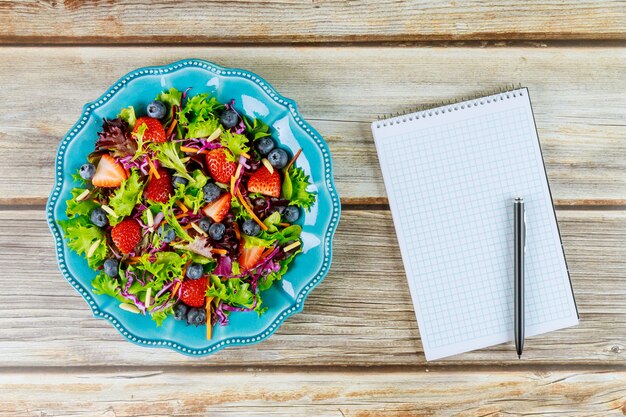 Foto mooie salade met blocnote en pen voor snelle memo