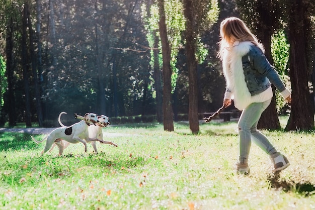 mooie schattige gelukkige blonde vrouw eigenaar met haar twee witte whippet buiten