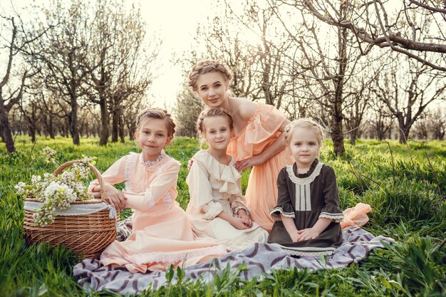 Mooie schattige meisjes in de tuin genieten van de komst van lentejurken in vintage stijl concept van tederheid uit de kindertijd