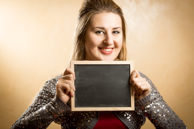 Mooie schattige vrouw poseren met zwarte schoolbord