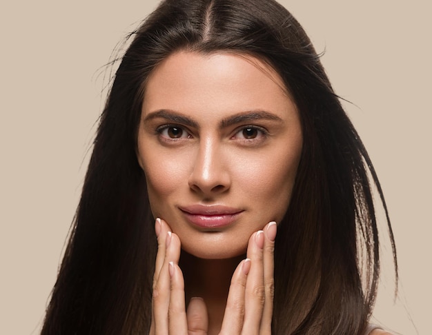 Mooie schone huid vrouw gezonde huid natuurlijke make-up model gezicht aan te raken. Kleur achtergrond bruin