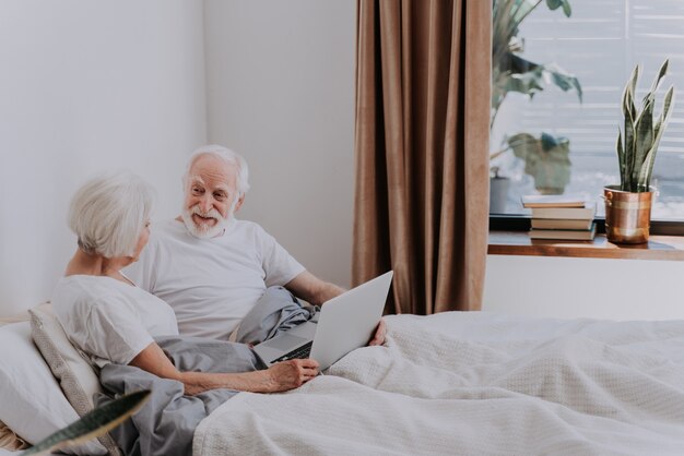 Mooie senior paar genieten van tijd samen thuis - Moder bejaarde echtpaar surfen op het internet op laptopcomputer