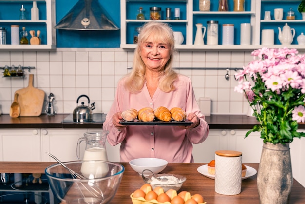 Mooie senior vrouw bakken in de keuken