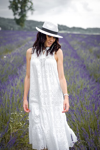 mooie sensuele jonge vrouw met hoed en witte jurk op het lavendelveld