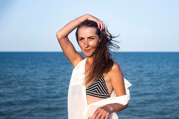 Mooie sexy jonge vrouw op de achtergrond van de zee op een zomerdag