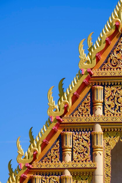 Mooie sier gouden Gable Apex op het dak van de traditionele Thaise tempel tegen de blauwe lucht