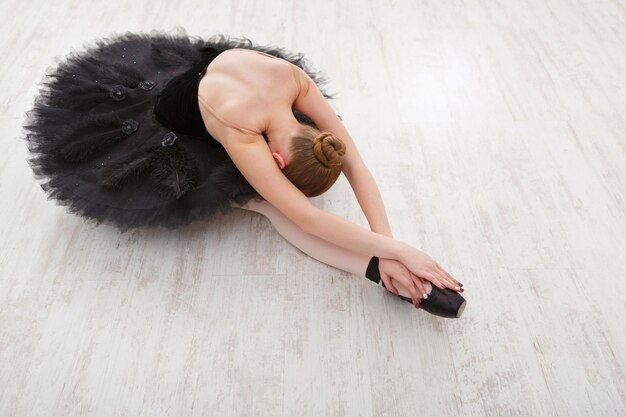 Mooie sierlijke ballerina in zwarte zwanenjurk. jonge balletdanser oefenen voor optreden in zwarte tutu, klassieke dansstudio, kopieer ruimte