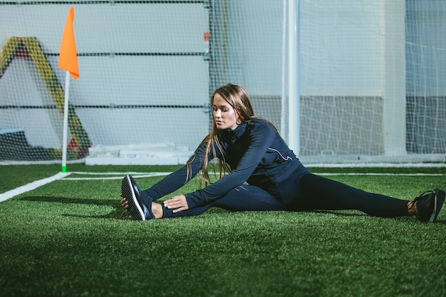 Mooie slanke jonge vrouw in sportkleding houdt zich bezig met het sportstadion