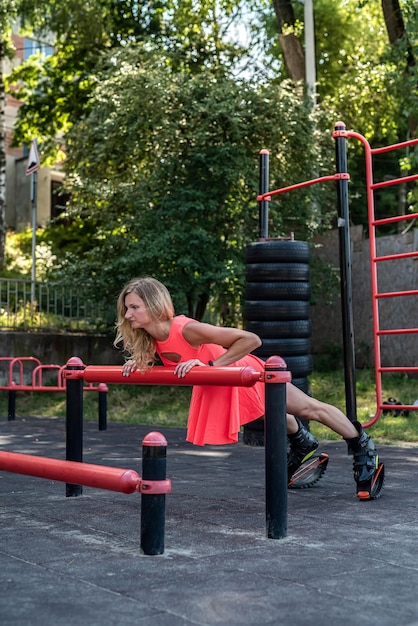 Mooie slanke vrouw in kangoo-sprongen die trainen op straatsimulators