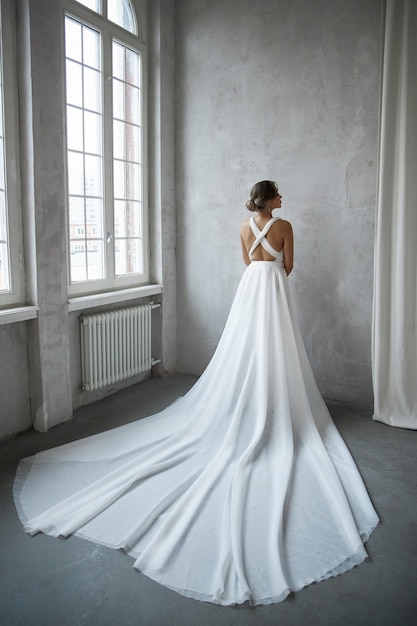 Mooie slanke vrouw in witte trouwjurk, nieuwe collectie jurken voor de bruid