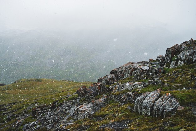 Mooie sneeuwval in de bergen Sfeervol groen alpine landschap met grote sneeuwvlokken