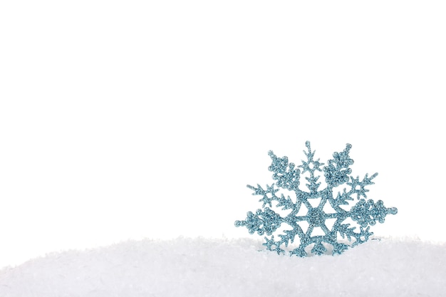 Mooie sneeuwvlok in de sneeuw die op wit wordt geïsoleerd