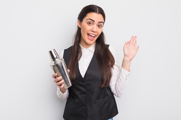 Mooie Spaanse vrouw die vrolijk lacht zwaaiend met de hand en verwelkomt je barman cocktail concept