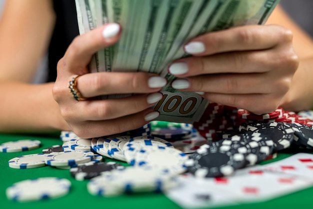 Mooie spelersvrouw telt fiches voor geld en verhoogt de inzet tijdens het pokeren in het casino