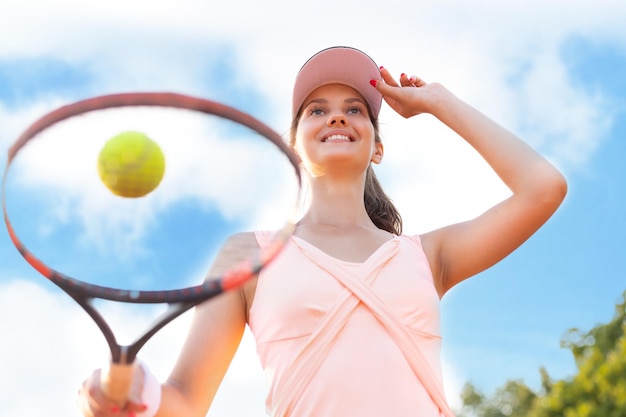 Mooie sportvrouw met racket op de tennisbaan Gezonde levensstijl