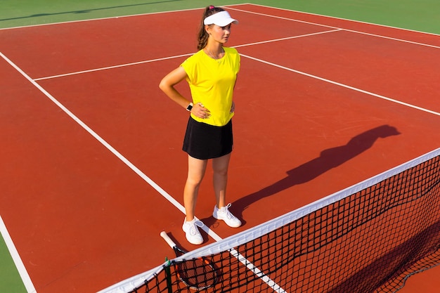 Mooie sportvrouw met racket op de tennisbaan Gezonde levensstijl