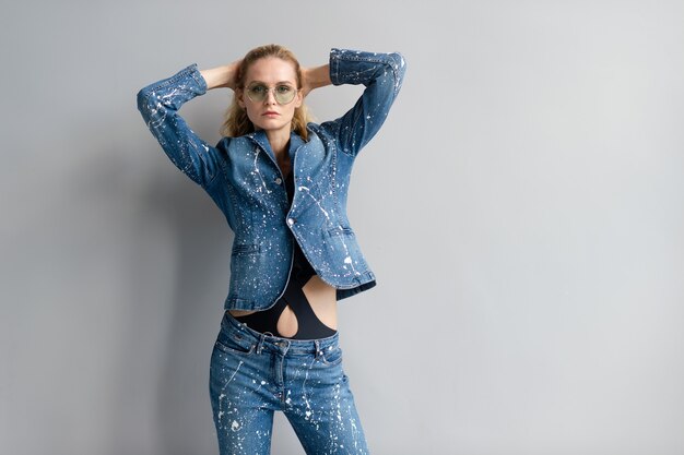 Mooie stijlvolle blonde model in jeans pak poseren